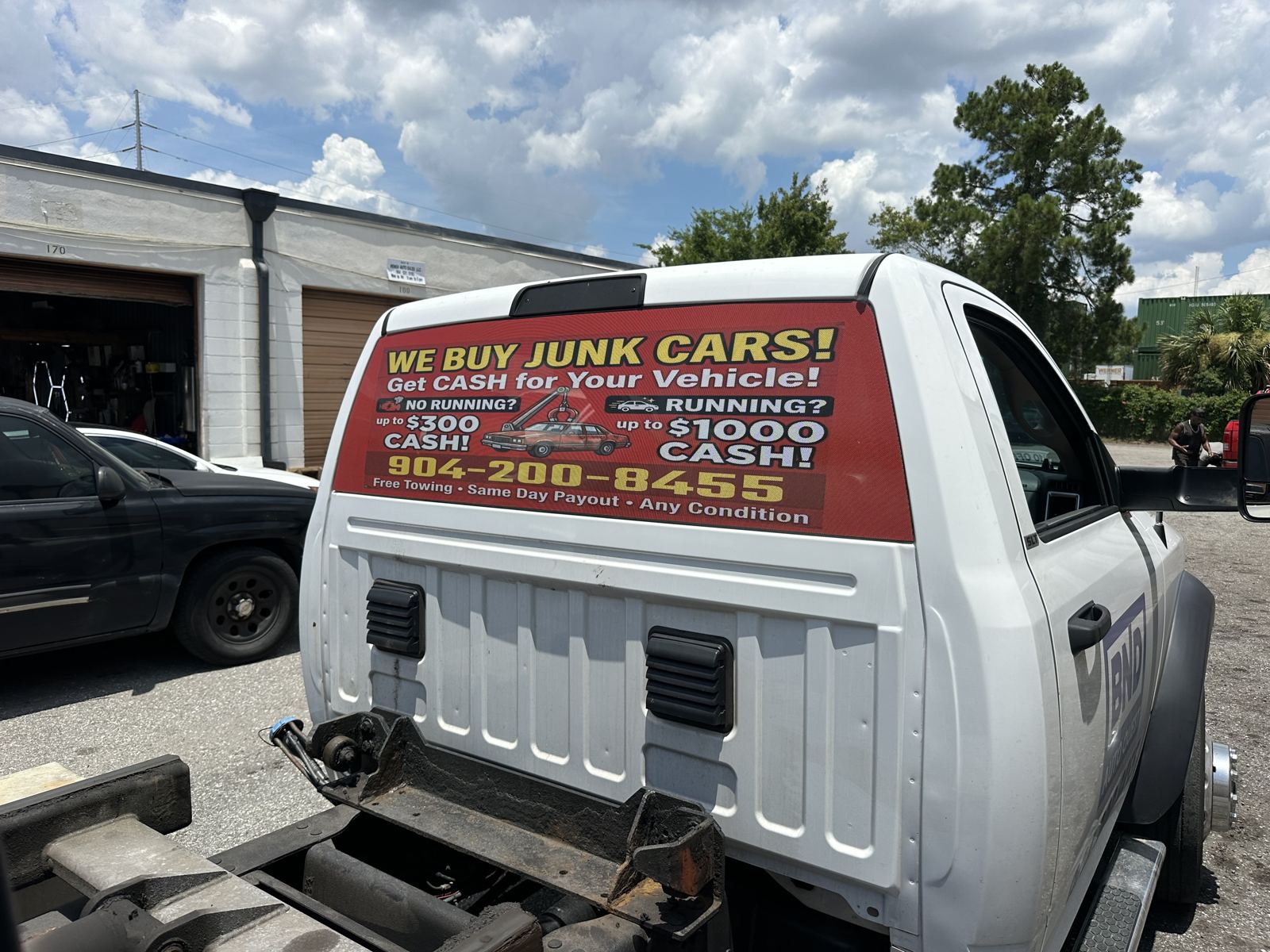 Vinil impreso «We Buy Junk Cars» instalado en la ventana trasera de una grúa
